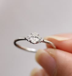 a person holding a diamond ring in their hand