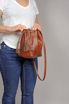 Mini Leather Bucket bag - caramel brown drawstring bag. Unlined The 35.5 inch (90 cm) strap has no adjustment. Brown Bucket Shoulder Bag With Dust Bag, Handmade Brown Hobo Bag As Gift, Brown Hobo Bag With Adjustable Strap As Gift, Brown Pouch Bucket Bag For Gift, Brown Bucket Pouch For Everyday Use, Casual Brown Tote Pouch, Cognac Soft Leather Bucket Bag, Handmade Brown Pouch For Everyday Use, Camel Bucket Bag For Everyday Use