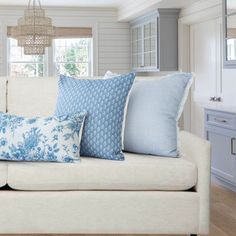 a white couch with blue pillows on it