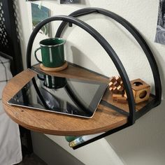 a wooden shelf with a tablet on it and a cup sitting on top of it