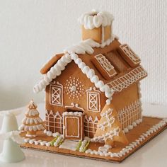 a gingerbread house made to look like it is on top of a cake plate