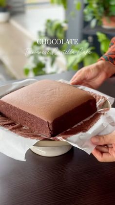 a person holding a piece of chocolate cake