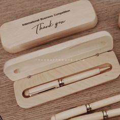 three wooden pens in their presentation cases on a table with the words, thank you