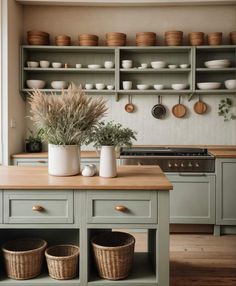 a kitchen filled with lots of green cabinets and wooden counter top next to an oven