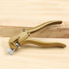 a pair of gold pliers on a wooden surface