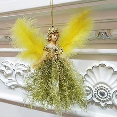 a yellow angel ornament hanging from a wall