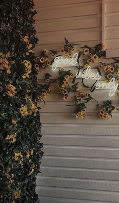 there is a sign that says good morning on the side of a building with sunflowers