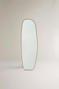 an oval mirror sitting on top of a white floor