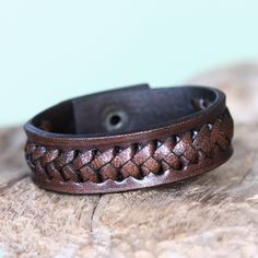 This bold bracelet by Tomomi showcases braided textures. Featuring interlacing created by hand, the wristband is handcrafted of brown leather. Brown Leather Strap Bracelet, Braided Brown Leather Jewelry, Brown Braided Leather Jewelry, Brown Leather Braided Jewelry, Handmade Leather Braided Bracelet, Brown Braided Leather Bracelets, Brown Leather Strap Braided Bracelet Gift, Brown Leather Braided Bracelet, Handmade Leather Braided Bracelets, Adjustable