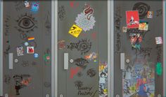 three doors covered in graffiti and stickers