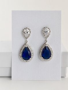 Luxury blue sapphire cubic zirconia bridal tear drop earrings in rhodium plated brass setting. Earrings feature a large teardrop with pear cut blue sapphire cubic zirconia center surrounded by tiny round zirconia crystals. Teardrop dangles from a bright cubic zirconia ear stud. Total length of the earring is 3.5 cms. For matching necklace click: https://www.etsy.com/listing/252864712/blue-sapphire-cubic-zirconia-teardrop?ref=shop_home_active_1 For matching bracelet: https://www.etsy.com/listing/ Sapphire Pear-shaped Wedding Jewelry, Pear-shaped Sapphire Wedding Jewelry, Pear-shaped Sapphire Silver Earrings, Blue Sterling Silver Chandelier Earrings For Wedding, Blue Teardrop Chandelier Earrings For Anniversary, Blue Cubic Zirconia Teardrop Earrings For Wedding, Blue Cubic Zirconia Teardrop Earrings, Sapphire Crystal Teardrop Earrings, Blue Pear-shaped Earrings For Weddings