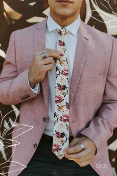 a man wearing a pink suit and floral tie