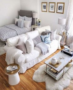 a living room filled with white furniture and lots of pillows on top of the couch