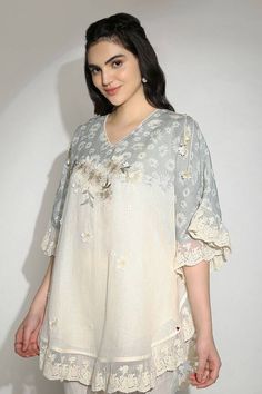 Off white and ice blue top with hand embroidery of anchor and silk threads embossed on top of screen-printed daisy flowers, highlighted with delicate 3d flowers, and daisy tassels dangling over the shoulders and sleeves. - Aza Fashions White V-neck Top With Intricate Embroidery, Elegant Short Sleeve Top With Resham Embroidery, Cream Chikankari Embroidered Summer Tops, Cream Tops With Chikankari Embroidery For Summer, Summer Cream Tops With Chikankari Embroidery, Cream Summer Tops With Chikankari Embroidery, Spring Linen Top With Chikankari Embroidery, Elegant V-neck Top With Chikankari Embroidery, Elegant Short Sleeve Top With Chikankari Embroidery