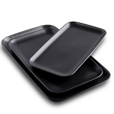 two black plates sitting side by side on top of each other, one is empty