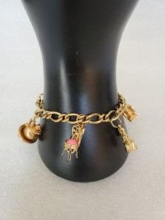 This listing is for an Avon gold tone charm bracelet with five Victorian style charms. This bracelet is no longer available on their website and so therefore it is collectible. The charms include: a Victorian chair with a pink cushion a pitcher bowl telephone and a meat grinder and an old boot with teal bead. All charms and chain are in excellent condition and will arrive in Avon Original box with FREE SHIPPING. Measures:  7 1/2"L Owl-1 X 1.8 cm Chair-0.8 X 2 cm Boot-1.3 X 2cm Grinder-1.8 X 0.6 Vintage Gold Charm Bracelet With Dangling Charms, Vintage Gold Bracelet With Charms, Vintage Gold-tone Charm Bracelet As Gift, Vintage Gold Bracelets With Dangling Charms, Vintage Gold Charm Bracelet Collectible, Pink Cushion, Victorian Chair, Old Boots, Pink Cushions