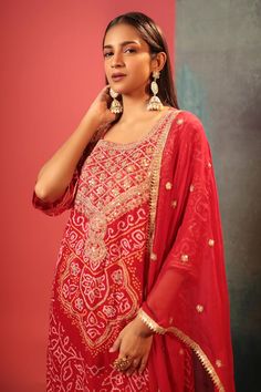 Red kurta with bandhani woven motifs and gota embroidered neckline. Paired with embroidered dupatta.
Components: 2
Pattern: Woven, Embroidery
Type Of Work: Bandhani, gota
Neckline: U neck
Sleeve Type: Three quarter
Fabric: Silk
Color: Red
Other Details: 
Cutwork border
Attached lining
Kurta Length: 47 inches
Note: Pant worn by the model is not for sale
Occasion: Sangeet - Aza Fashions Festive Bandhani Print Straight Kurta Anarkali Set, Festive Semi-stitched Bandhani Print Choli, Festive Anarkali Set With Bandhani Print For Diwali, Semi-stitched Bandhani Print Choli For Festive Occasions, Chanderi Bandhani Print Lehenga With Straight Kurta, Festive Bandhani Print Sharara, Festive Bandhani Print Lehenga, Festive Anarkali Sharara With Bandhani Print, Red Kundan Sets With Dupatta