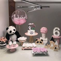 a table topped with lots of cakes and cupcakes next to a giant balloon