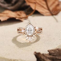 a close up of a ring on top of a table with leaves in the background