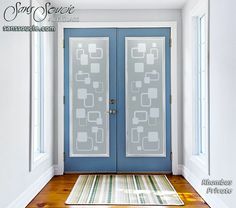 a blue front door with two glass panels and a rug on the floor next to it