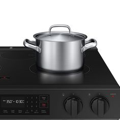 a black stove top with a pot on it's burner and timers