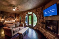 a living room with a couch, fireplace and large screen tv in it's corner