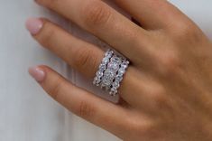 a woman's hand with a diamond ring on top of her left hand,