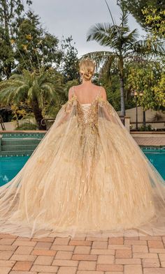 Gold long a-line quinceanera ball gown with off the shoulder long sheer draped cape sleeves. Ball Gown Prom Dresses Gold, Wedding Dress With Gold Leaf, Queen Dress Royal Fantasy Gold, Gold Wedding Dress Ballgown, Fantasy Gowns Queens, Gold Ballgown, Gold Princess Dress, Dresses Fantasy Gowns, Queen Cape