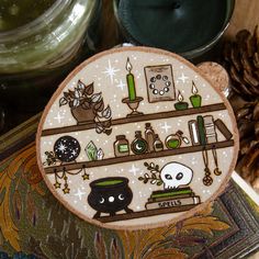 a wooden plaque with various items on it sitting next to some pine cones and candles