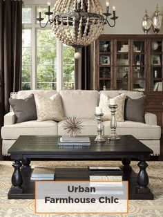 a living room filled with furniture and a chandelier hanging from the ceiling in front of a window