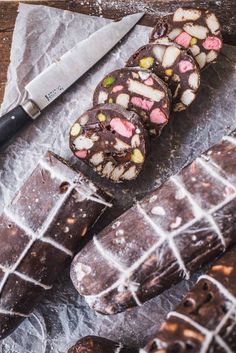 chocolate and marshmallows are arranged on a cutting board next to a knife