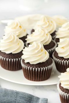 chocolate cupcakes with white frosting on a plate