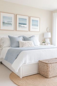 a bedroom with white and blue bedding, pictures on the wall above the bed