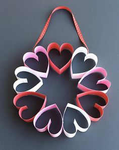 several heart shaped paper hangings on a gray surface