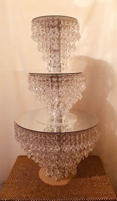 three tiered glass cake stand sitting on top of a table