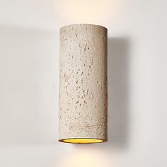 a light that is on the wall next to a white wall with a yellow light in it