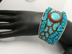 Beautiful and elegant bracelet in a slightly ethnic style, hand embroidered with a central turquoise cabochon and aulite gems. It is difficult and slow work, it took many hours of work from planning to realization of the final project. Each bead is individually hand sewn to create the final design. Inside the bracelet is covered in natural leather which gives a soft touch to the skin. This bracelet is comfortable to wear, goes perfectly with clothes of different colors. The colors used recall summer, the sea and the sun... The width of the bracelet is 4cm (1.6 inches). It has a brass plate inside that holds its shape and fits any wrist size. Wearing this bracelet will make you feel unique and special. Each piece is unique. If you would like a personalized bracelet in the colors of your cho Bohemian Beaded Cuff Jewelry, Bohemian Embroidered Bangle Bracelets, Bohemian Handwork Jewelry As Gift, Bohemian Multicolor Handwork Jewelry, Artisan Turquoise Beaded Bangle Bracelets, Artisan Turquoise Beaded Bangle Bracelet, Turquoise Beaded Cuff Bracelet For Gift, Turquoise Beaded Cuff Bracelet With Round Beads, Artisan Beaded Turquoise Cuff Bracelet