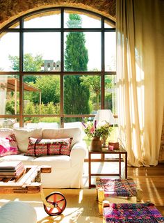 a living room filled with furniture and large windows