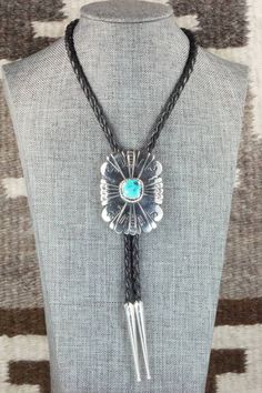 This turquoise and sterling silver bolo tie was made by Navajo silversmith Rosita Singer. The back is signed T&R Singer and stamped sterling.Tie Length: 22"Length: 2 3/8"Width: 1 3/4"Tips:Length: 2 1/8"Width: 1/4"Free shipping on all orders! We ship with USPS and always include tracking. All orders ship within a day of payment.Returns are accepted up to 30 days after you receive your order. Just send us a message. Our shop offers cash back or store credit. The item must be returned in new condit Vintage Concho Lariat Necklace, Southwestern Lariat Bolo Tie For Rodeo, Vintage Style Concho Lariat Necklace, Western Style Concho Jewelry As Gift, Western Style Concho Jewelry For Gift, Southwestern Engraved Jewelry For Western-themed Events, Artisan Hand-tooled Jewelry For Rodeo, Vintage Concho Lariat Jewelry, Concho Lariat Bolo Tie For Western-themed Events