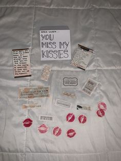 a white sheet with red lipstick on it next to some notes and magnets that say you miss my kisses