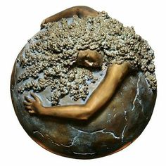 a bronze sculpture of a woman sleeping on a rock with her arms around the head