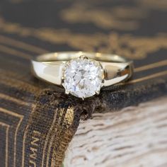 a diamond ring sitting on top of an old book