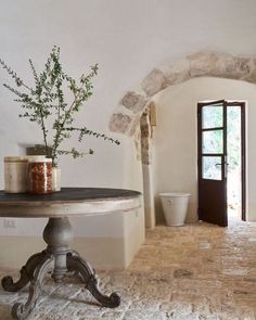 a table with a potted plant sitting on top of it next to a doorway