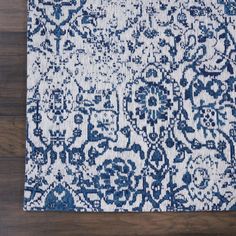 a blue and white rug on top of a wooden floor