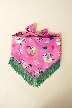 a pink dog bandana with green fringes on it