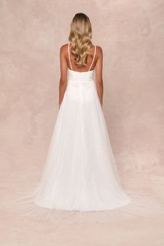 a woman in a white wedding dress looking down at the back of her head and shoulders