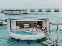 a man laying on top of a floating bed in the ocean next to a dock