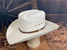 Made in the USA Straw material Cattleman crease 4 1/4' Brim Leather sweatband Eyelet vents along crown Outside leather band w/ small logo pin Sizes: 6 3/4" - 7 3/4" White Western Hat With Flat Bill, White Flat Bill Country Hat Bands, White Western Hat For Formal Occasions, White Western Formal Hat, White Flat Crown Hat For Rodeo, White Flat Brim Hat With Rigid Fit, White Rigid Flat Brim Hat, Classic White Hat Bands For Rodeo, Classic White Hat Band For Rodeo