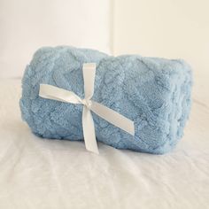 a blue blanket with a white ribbon tied around it