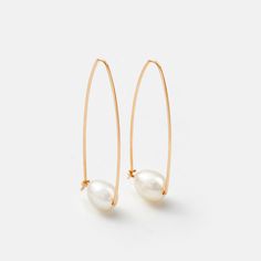 These Gold Pearl Drop Earrings are perfect for any modern wardrobe. Crafted from recycled gold filled metal, each earring features a unique and eye-catching freshwater pearl drop, ensuring every pair is one of a kind. These lightweight and timeless keepsakes are as beautiful as they are stylish. 1.5" long Ethically cultivated freshwater pearls Recycled 14k gold filled Minimalist Metal Pearl Drop Earrings, Modern Hoop Earrings With Pearl Charm, Minimalist Hoop Pearl Earrings With Ear Wire, Everyday Metal Hoop Earrings With Pearl Drop, Small Hoop Metal Pearl Drop Earrings, Small Hoop Pearl Drop Earrings In Metal, Gold Pearl Drop Earrings, Pearl Drop Earrings Gold, Pearl Hoop Earrings